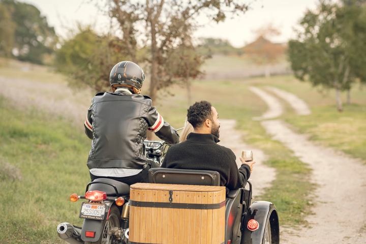 a man riding a motorcycle down a dirt road